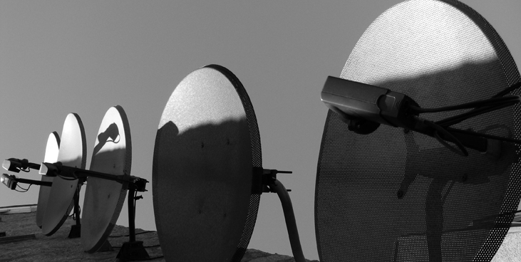 An array of large parabolic satellite dishes pointed at the sky.